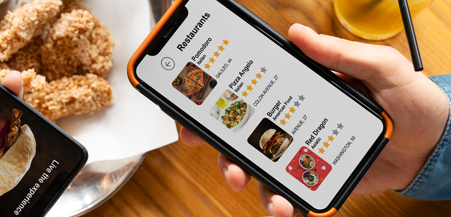 "A sleek restaurant interface displayed on a laptop and smartphone, highlighting a Web App for Restaurant Ordering in Lahore, with a cozy restaurant setting in the background."